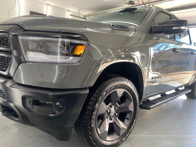 A gray ram truck is parked in a garage.