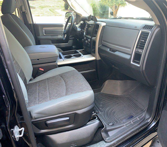 The interior of a black dodge ram truck with the door open