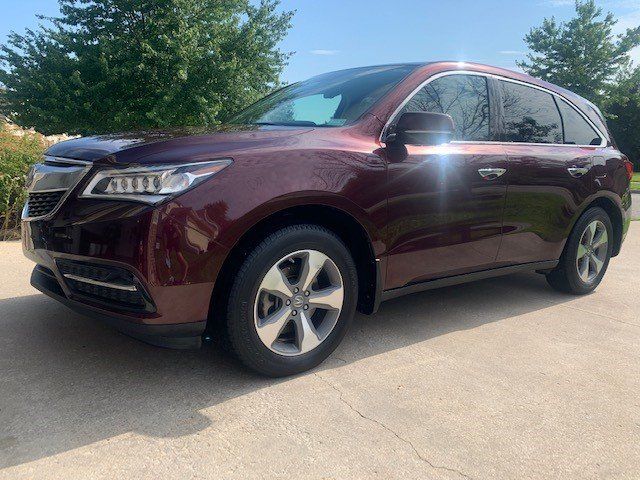A red acura mdx is parked in a driveway.