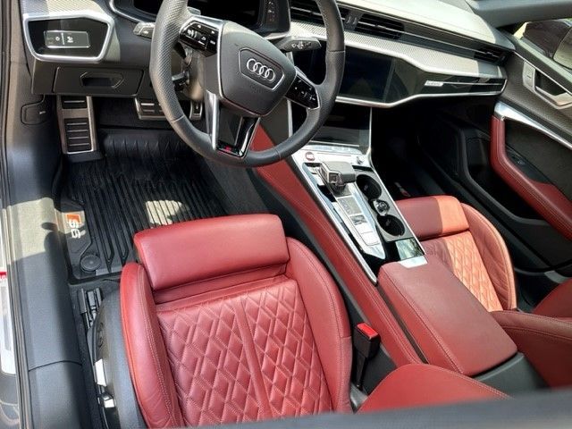 The interior of a car with red seats and a steering wheel