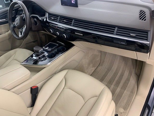 The interior of a car with tan leather seats and a steering wheel.