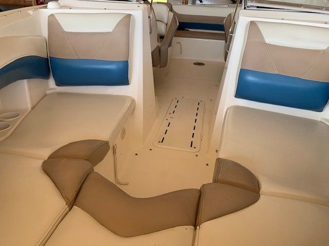 The inside of a boat with brown and blue seats