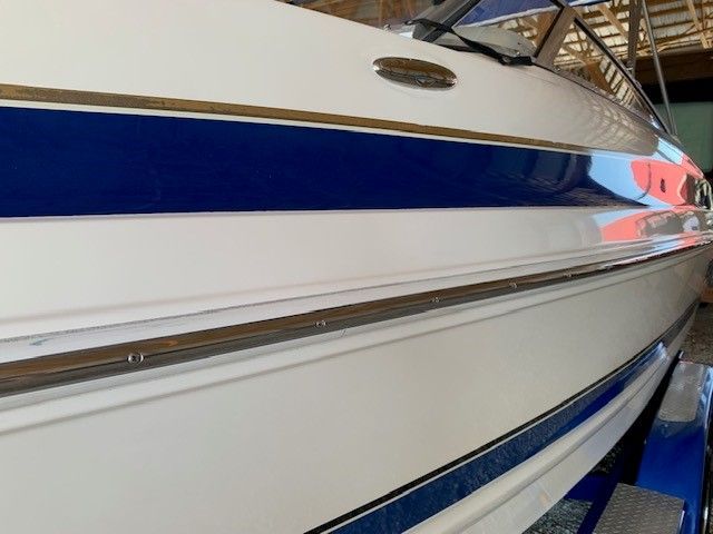 A white boat with blue stripes on the side