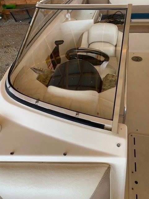 A white boat with a steering wheel and seats