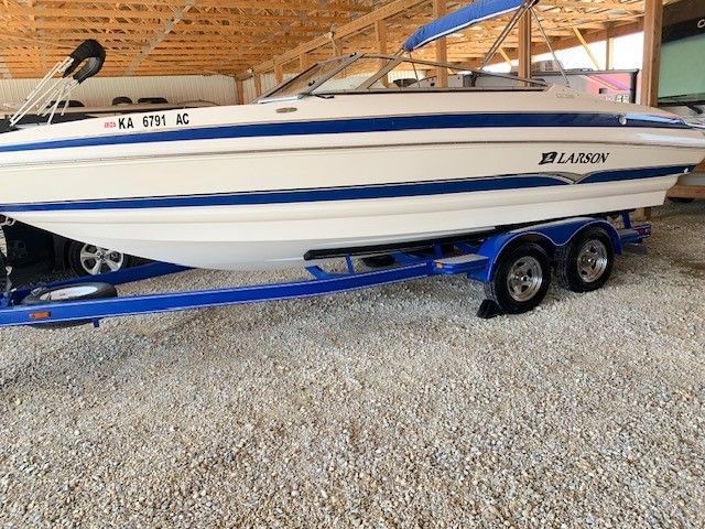 A white and blue boat is parked in a warehouse