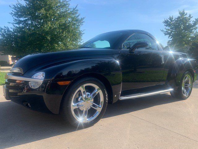 A black sports car is parked in a driveway.