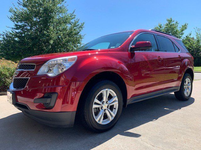 A red chevrolet equinox is parked on the side of the road.