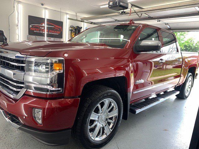 A red pickup truck is parked in a garage.