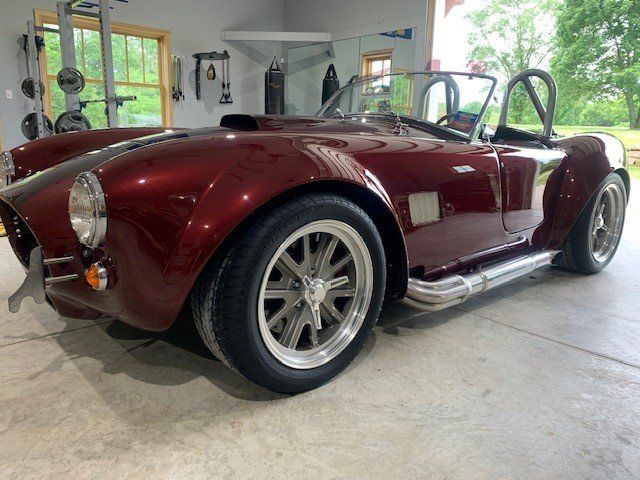 A red sports car is parked in a garage.