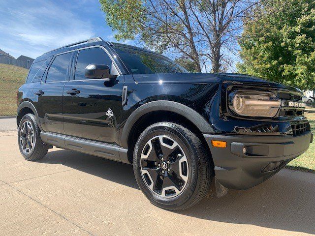 A black ford bronco sport is parked on the side of the road.