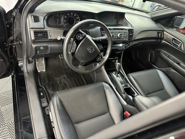 The interior of a black honda accord is shown with the door open.