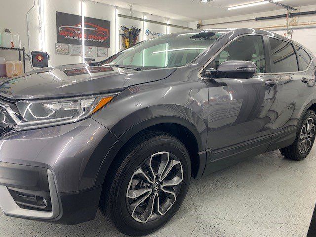 A gray honda cr v is parked in a garage.