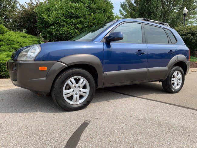 A blue suv is parked on the side of the road.