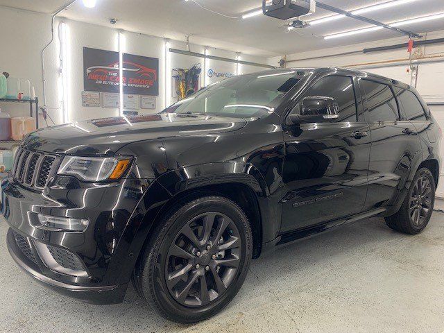 A black jeep grand cherokee is parked in a garage.