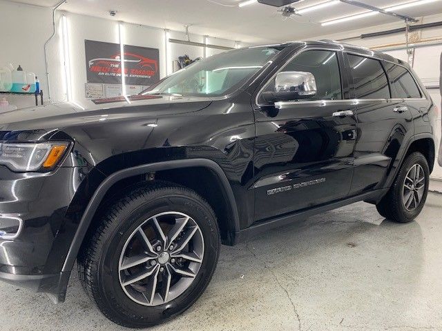 A black jeep grand cherokee is parked in a garage.