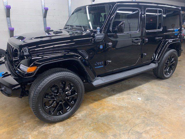 A black jeep wrangler is parked in a garage.