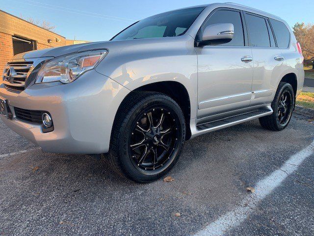A silver lexus gx is parked in a parking lot.