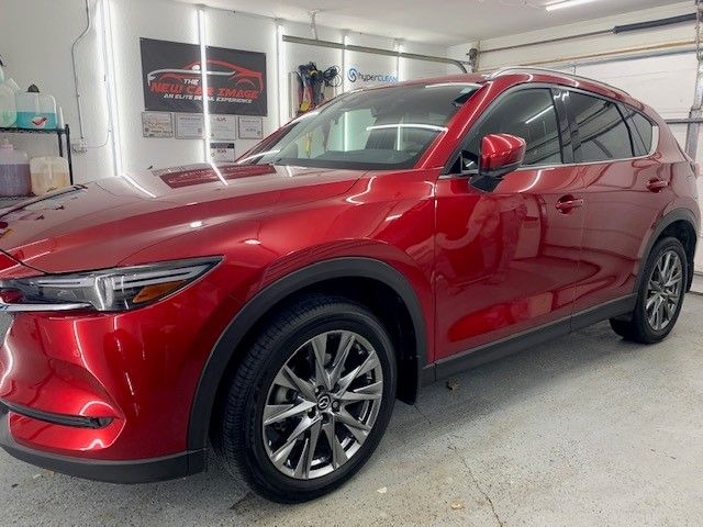 A red mazda cx-5 is parked in a garage.