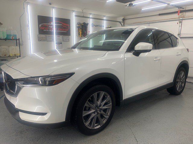 A white mazda cx-5 is parked in a garage.