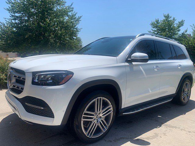 A white mercedes benz gls is parked in a driveway.