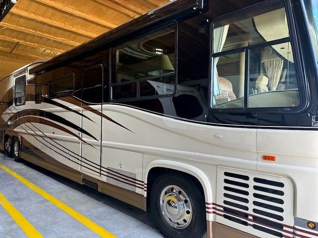A large rv is parked in a garage next to a yellow line.
