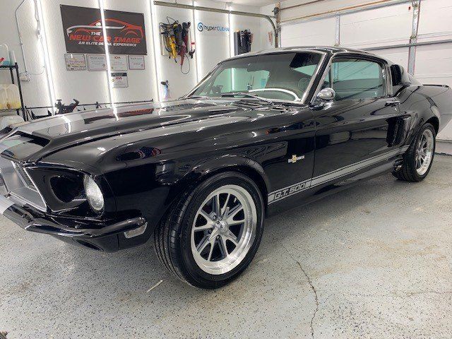 A black ford mustang is parked in a garage.