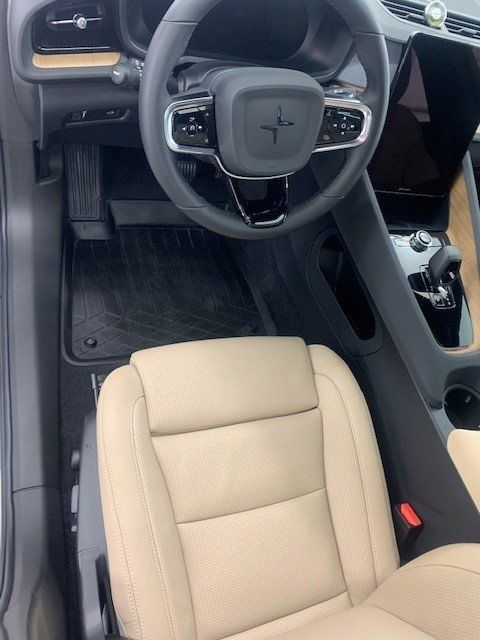 The interior of a car with a steering wheel and seats.