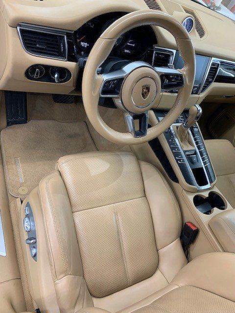 The interior of a porsche macan with tan leather seats