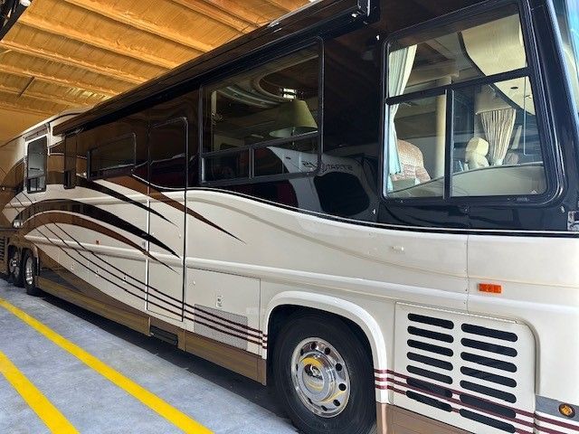 A large bus is parked in a parking lot with yellow lines.