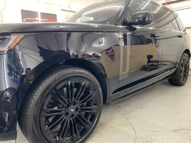 A black range rover is parked in a garage.