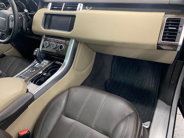 The interior of a range rover sport is shown with the door open.