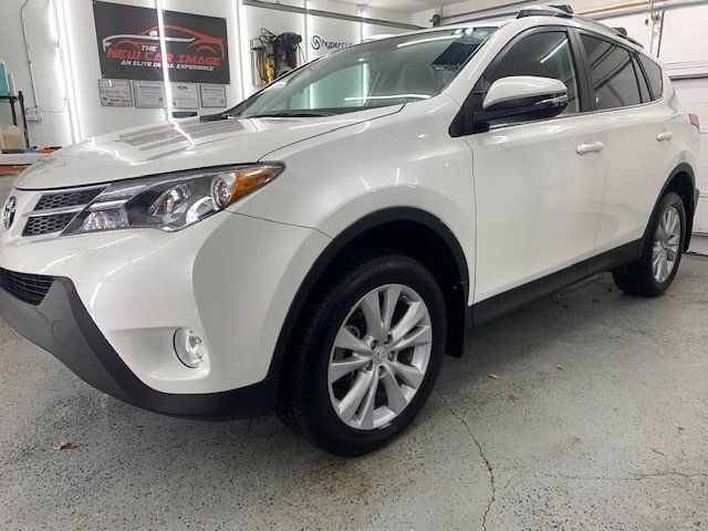 A white toyota rav4 is parked in a garage.