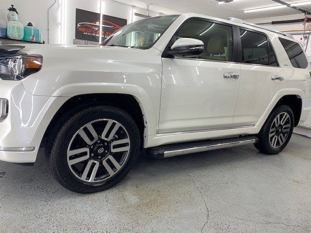 A white toyota 4runner is parked in a garage.