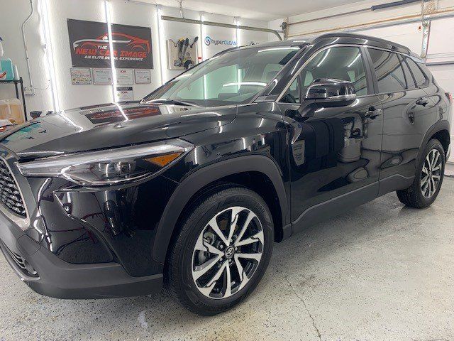 A black toyota corolla cross is parked in a garage.