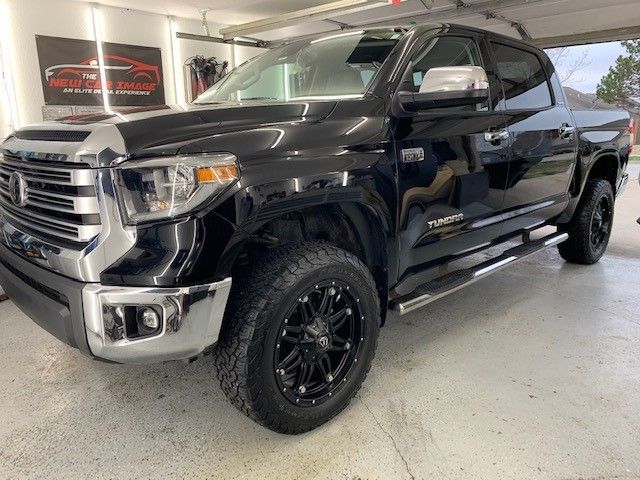 A black toyota tundra is parked in a garage.