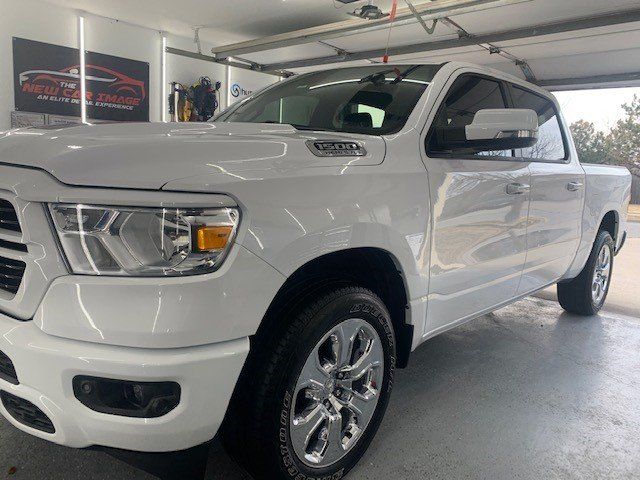 A white ram 1500 truck is parked in a garage.