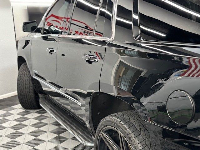 A black suv is parked in a garage with a checkered floor