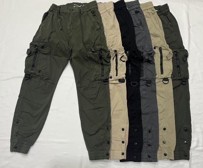 Una fila de pantalones cargo están alineados sobre una superficie blanca