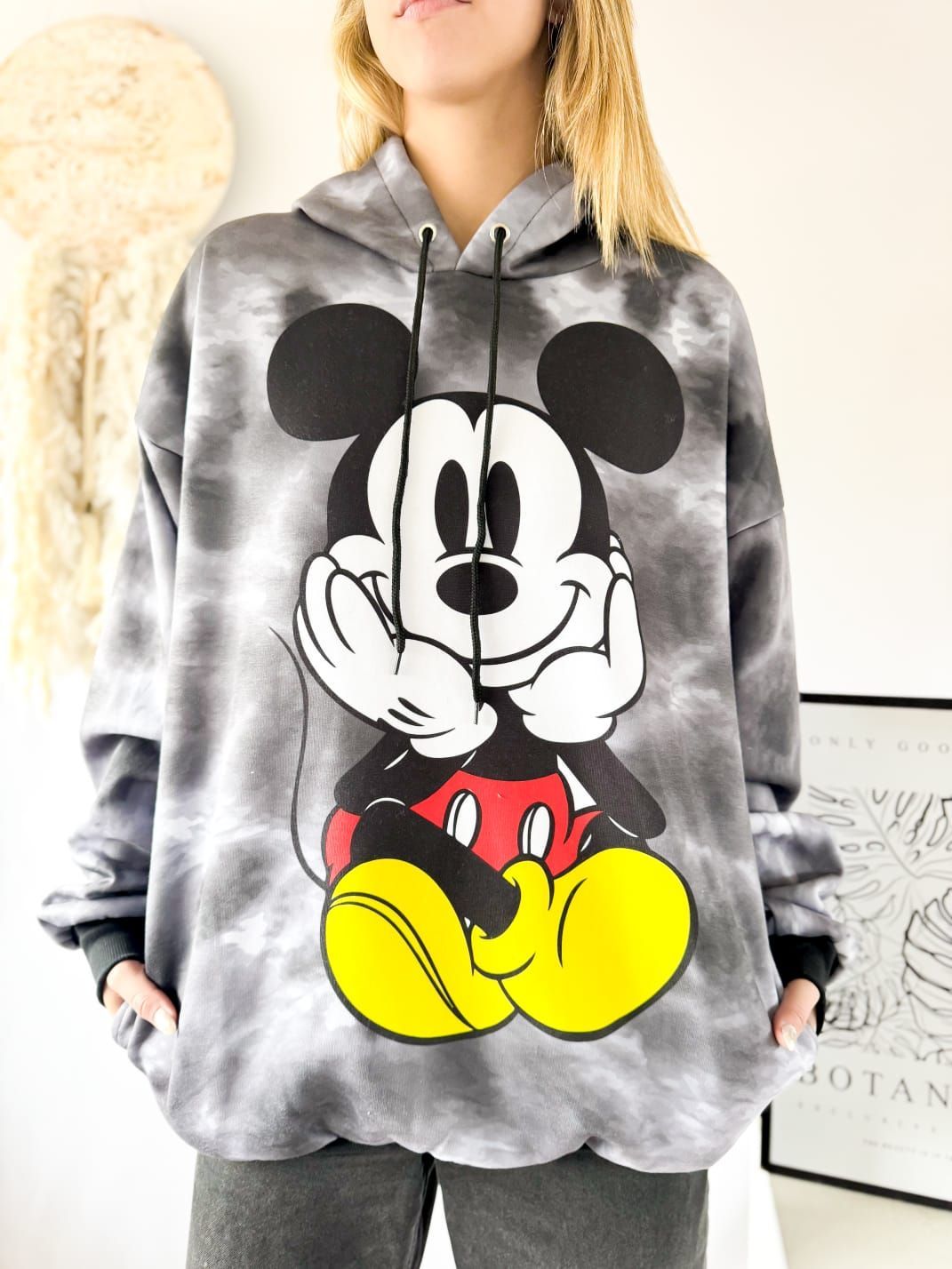 Una mujer lleva una sudadera con capucha teñida con Mickey Mouse.