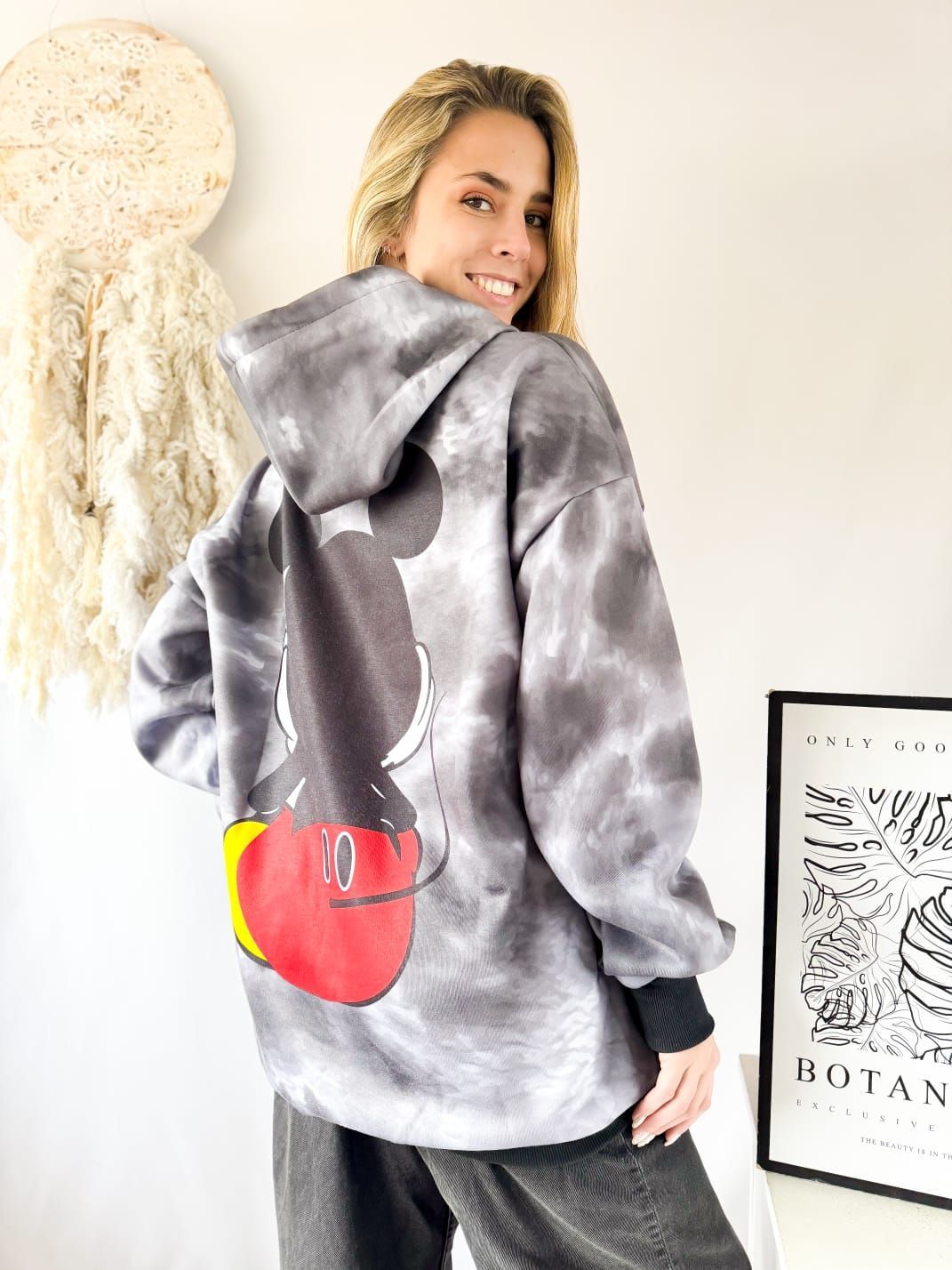 Una mujer lleva una sudadera con capucha teñida con Mickey Mouse.