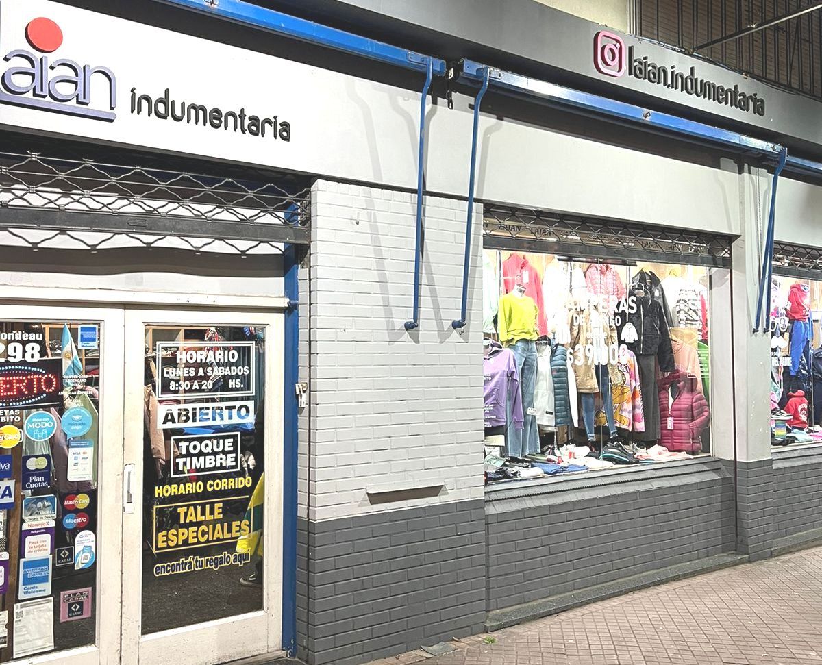 Un escaparate con un cartel que dice 'alan indumentaria'