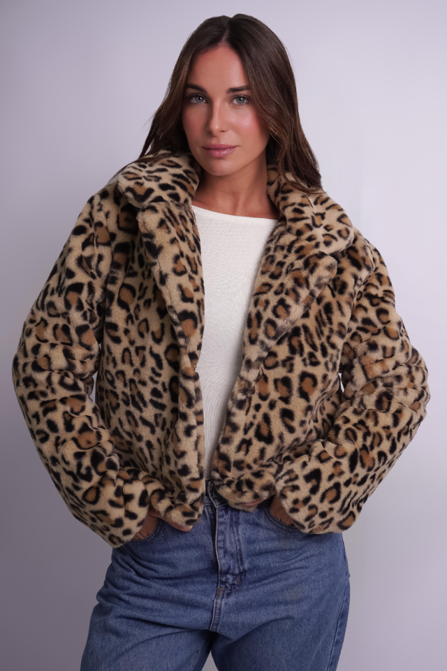 Una mujer lleva una chaqueta con estampado de leopardo y jeans.