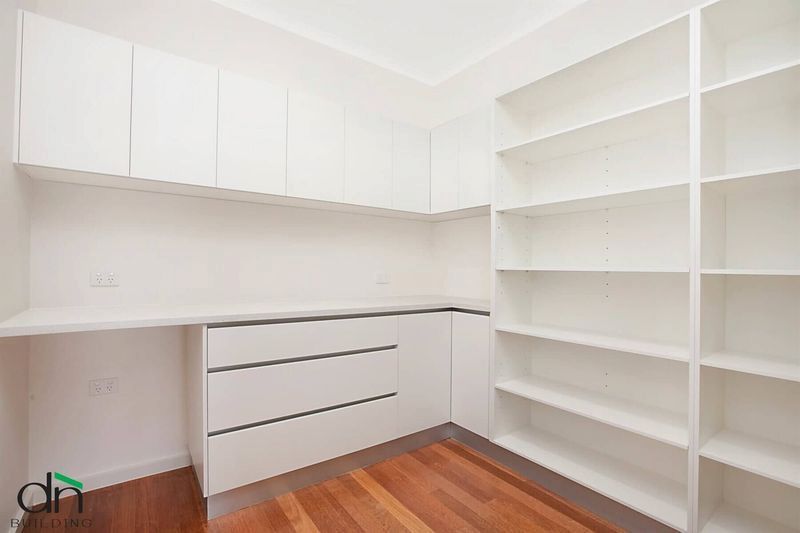 A Room With White Cabinets and Shelves and a Wooden Floor — Custom Cabinets Design in Winnellie, NT
