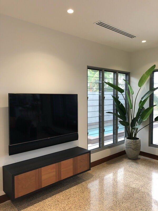 A Living Room with A Flat Screen Tv and A Potted PlantCustom Cabinets Design