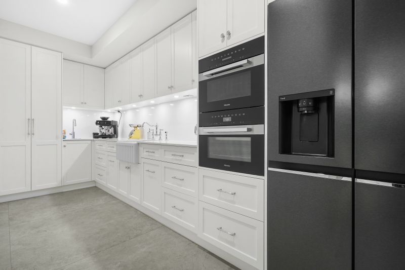A Kitchen With White Cupboards and dark Appliances — Custom Cabinets Design in Berrimah, NT