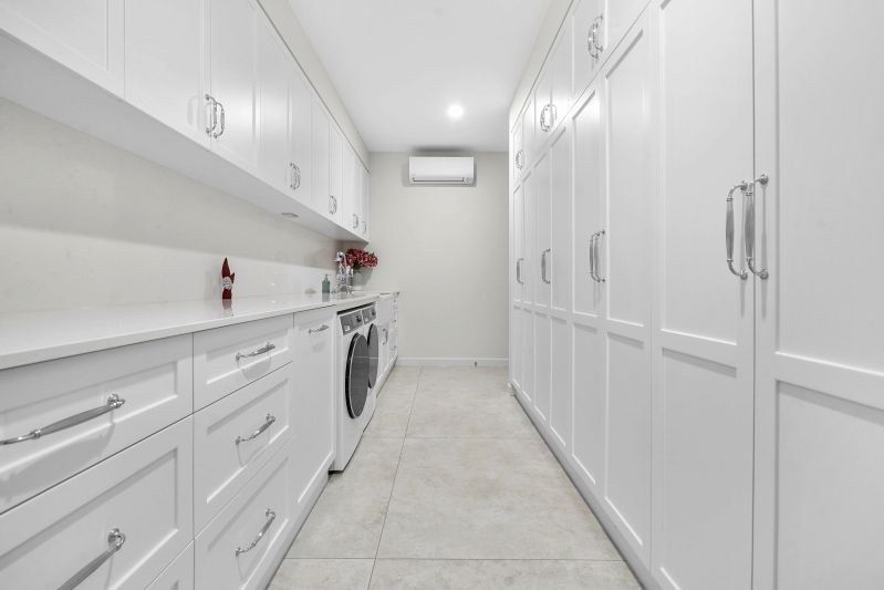 A Laundry Room white cabinetry and tiled floors — Custom Cabinets Design in Berrimah, NT
