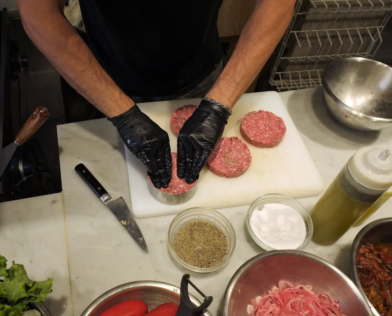 Bistecca tagliata a fette e grigliata con un rametto di rosmarino su un letto di lattuga, su un piatto di metallo.