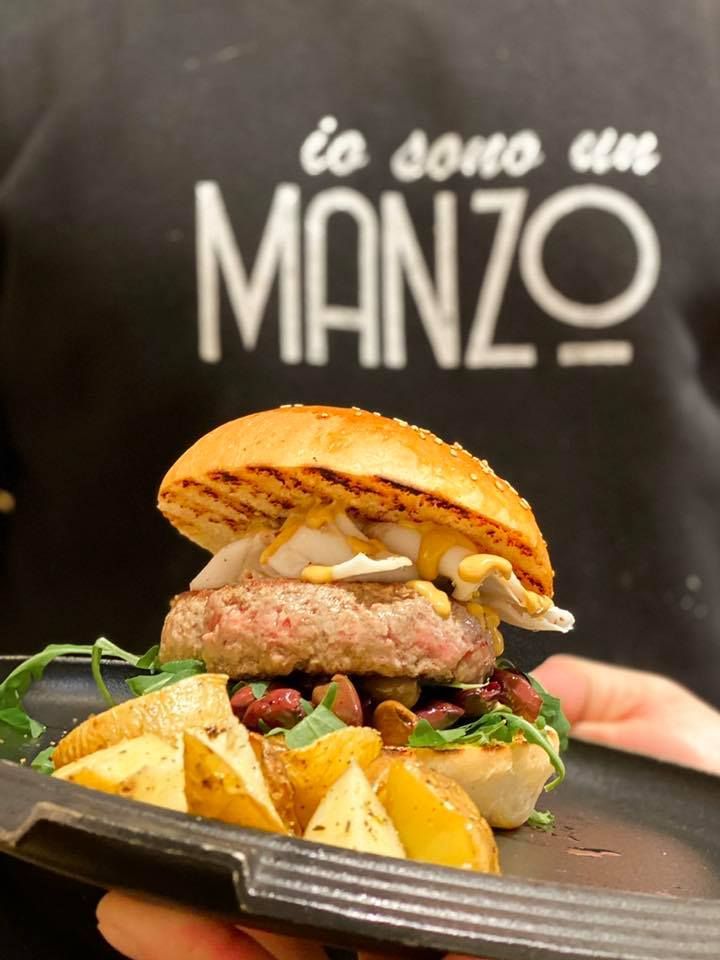 Carne cruda condita, disposta su un vassoio di metallo, pronta per la cottura.