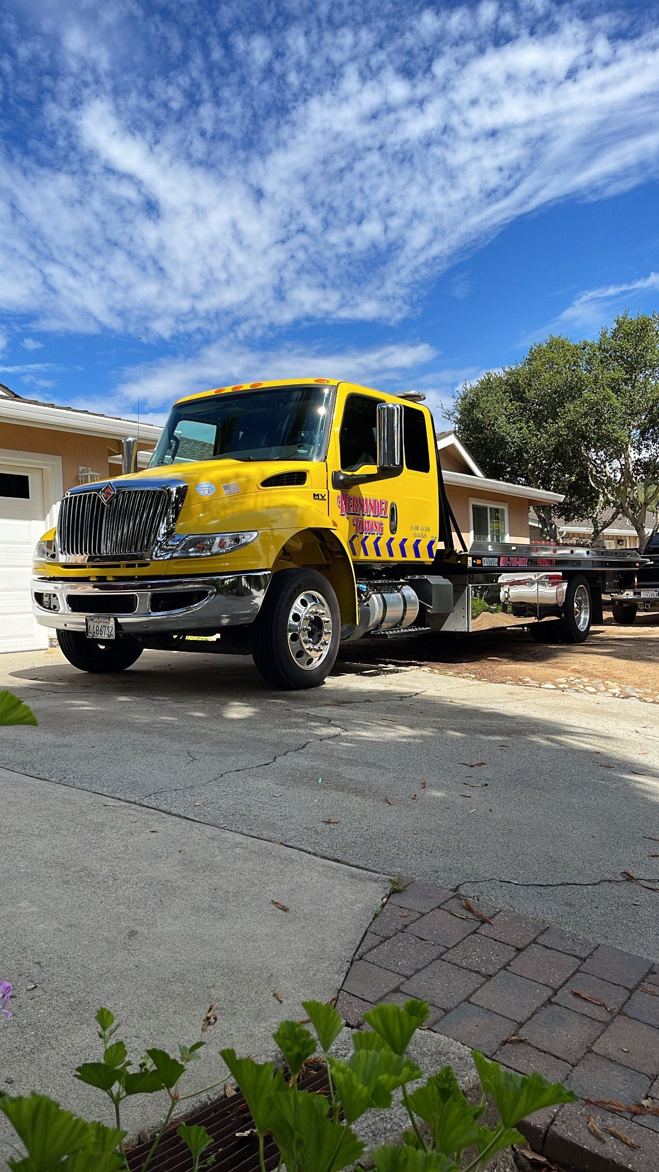 Damaged silver car on a tow truck, rear end crumpled.