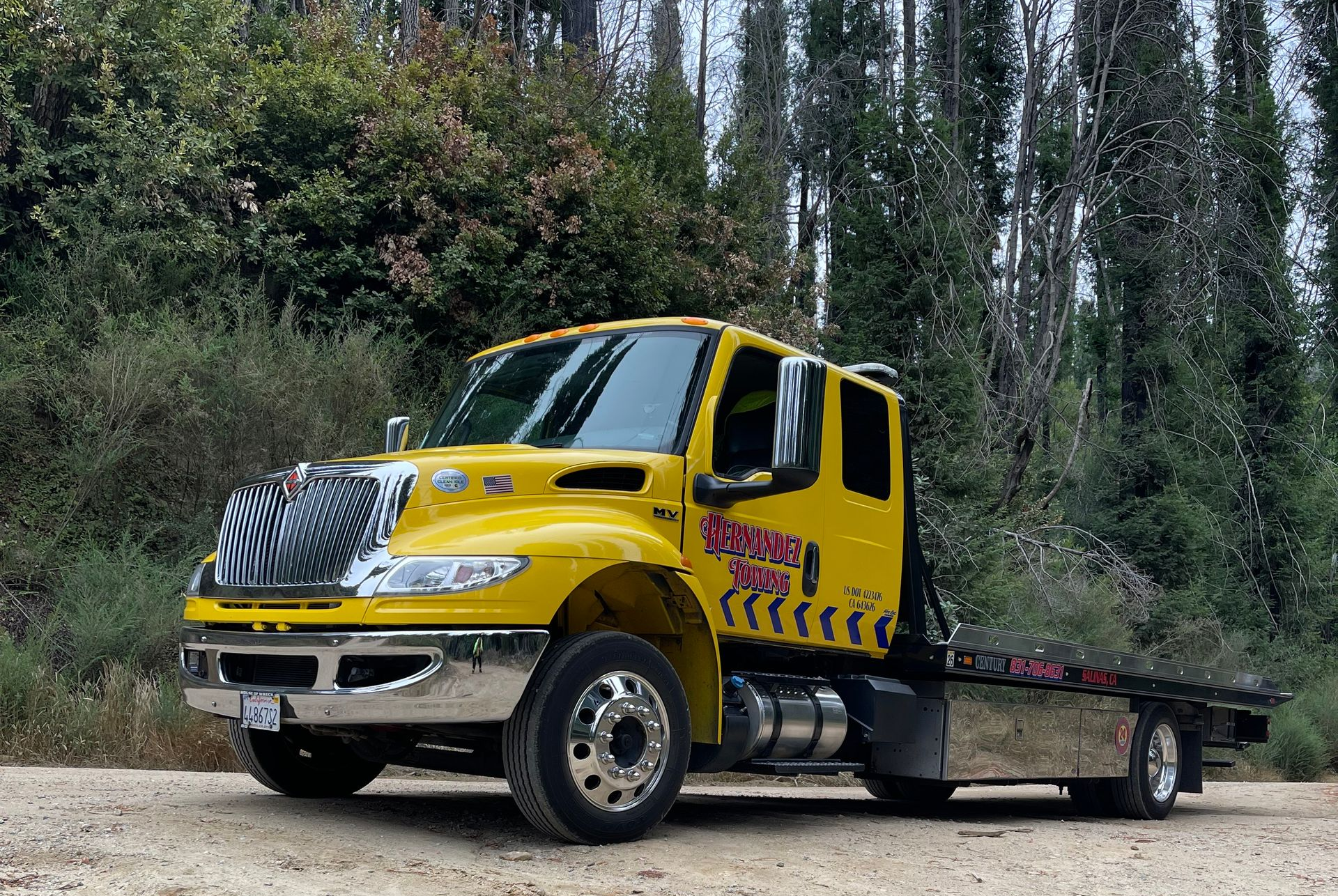 Red car being towed, wheel secured with black strap on a yellow ramp. Red car being towed, wheel secured with black strap on a yellow ramp.